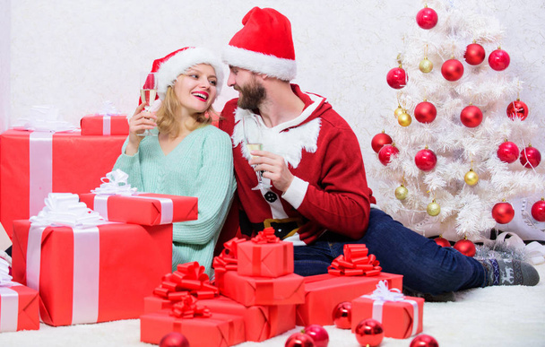 Celebrating christmas together. Couple in love enjoy christmas holiday celebration. Family tradition. Loving couple cuddle and drink champagne near christmas tree. Happy new year and merry christmas - Photo, image