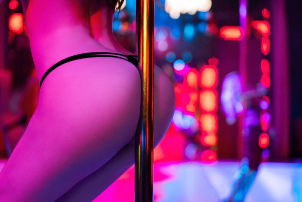 Obcasy seksownej kobiety tańczącej na rurze lub striptizerce. Pylon w nocnym klubie. Dziewczyna striptizerka tle - Zdjęcie, obraz