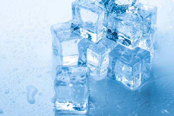 glaçons carrés avec gouttes d'eau propre sur fond bleu - Photo, image