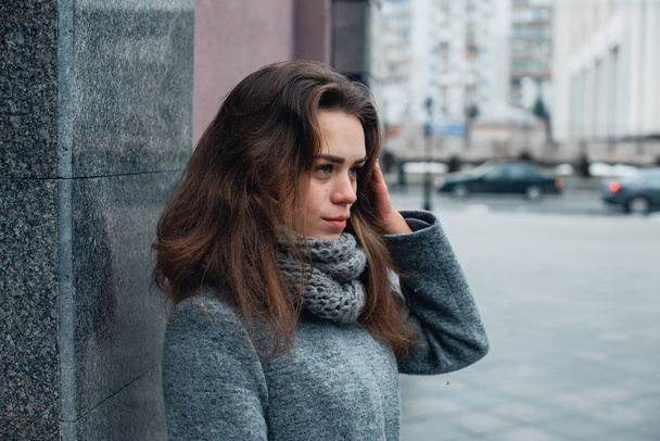 Girl in a gray coat in the winter in the city - Fotoğraf, Görsel