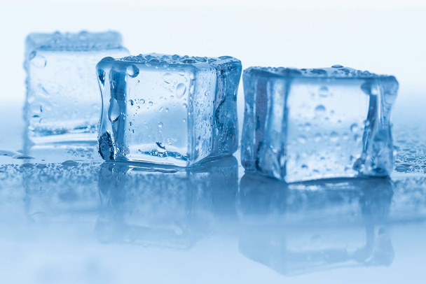 Ледяные кубики квадратные с капель воды чистой на голубом фоне - Фото, изображение
