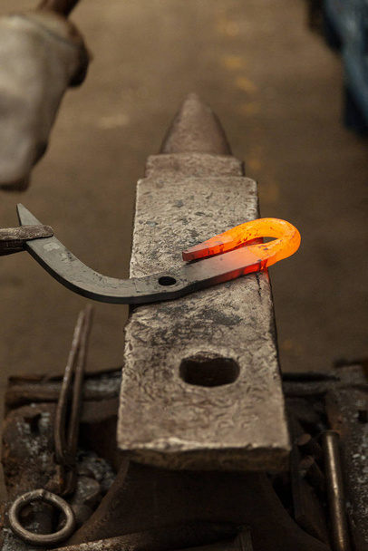 Gancho de metal caliente golpeando en la etapa final en yunque de fábrica
 - Foto, imagen