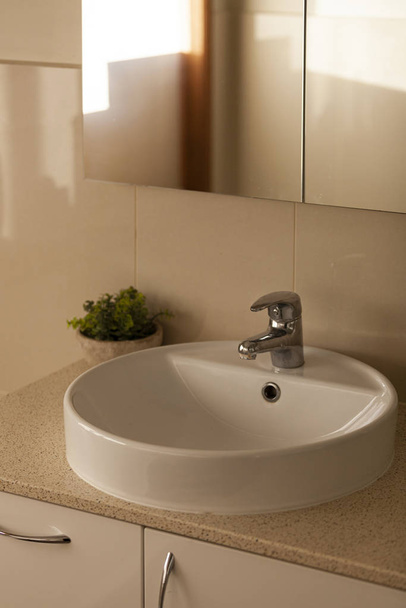 Robinet de salle de bain contemporain & vanité dans la lumière diffuse de l'après-midi résidentiel
 - Photo, image