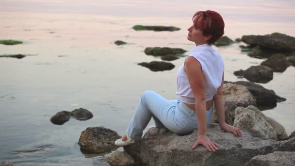 Шкідлива жінка сидить на березі моря увечері
 - Кадри, відео