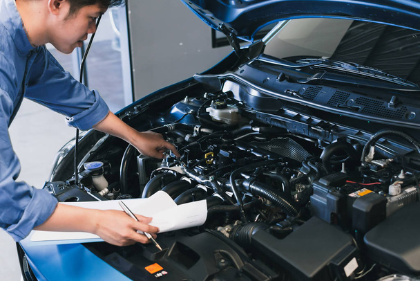 Asijský člověk mechanik inspekce psaní poznámky na schránce.Blue car - Fotografie, Obrázek