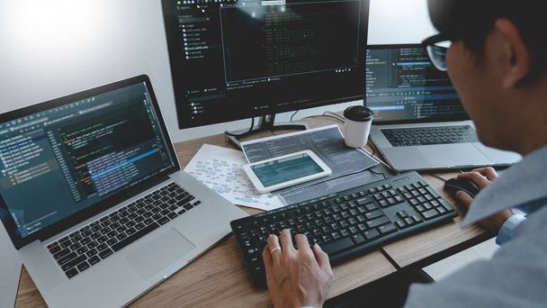 Programmer Typing Code on desktop computer, Developing programmi - 写真・画像
