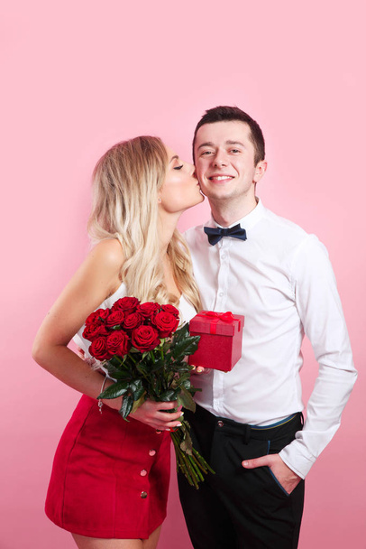 Couple dating on Valentines day . Romantic couple with flowers on pink background - Foto, imagen