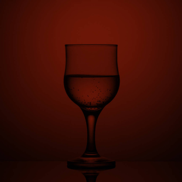 Empty wine glass on a red background - 写真・画像