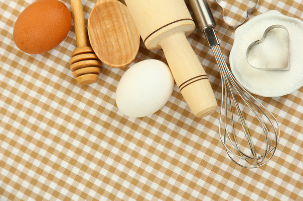 Kochkonzept. Grundlegende Backzutaten und Küchengeräte auf Tischdecken-Hintergrund - Foto, Bild