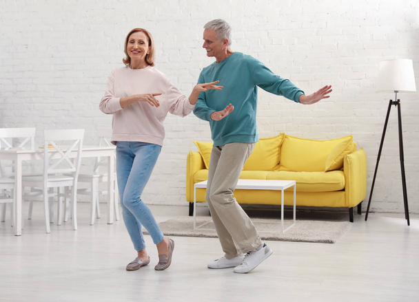 Happy senior couple dancing together in kitchen - Zdjęcie, obraz