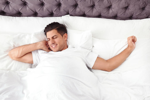 Man awakening in bed at home, top view. Lazy morning - Foto, Imagem