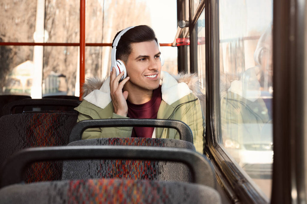 Man listening to audiobook in trolley bus - Fotó, kép