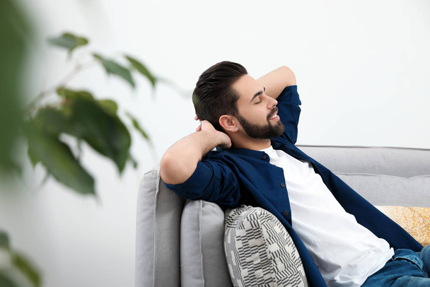 Young man relaxing on couch at home - Φωτογραφία, εικόνα