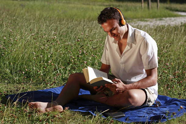 student with book and headphones ii - Foto, afbeelding