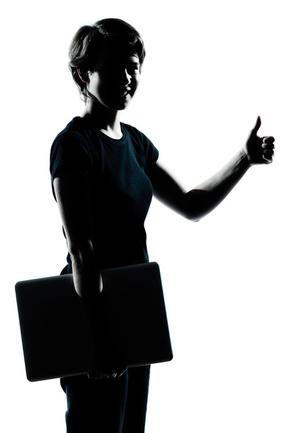 One young teenager girl silhouette holding carrying laptop compu - 写真・画像