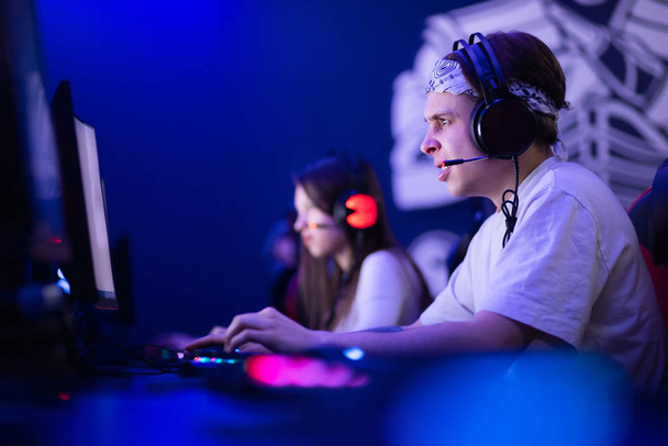 Team professional gamer playing tournaments online games computer with headphones, red and blue - Fotografie, Obrázek
