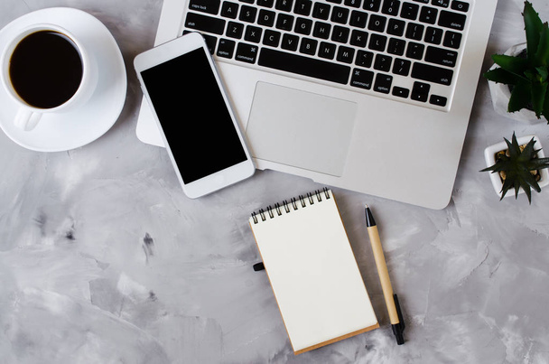 Bílý smartphone s černou prázdnou obrazovkou na kancelářském stole s notebookem a šálkem kávy. Vysmívat se telefonu. - Fotografie, Obrázek