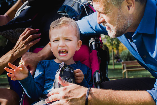 Un gamin qui pleure sur un parc. Papa essaie de calmer son fils.
 - Photo, image