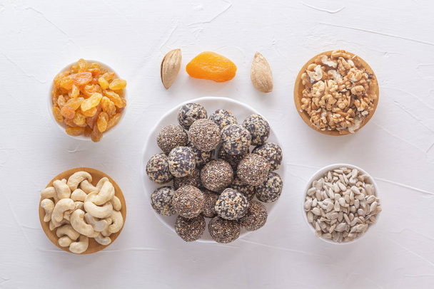 Luonnollinen terve raaka energia puree ja sekoita kuivattuja hedelmiä pähkinöillä valkoisella pöydällä. Yläkuva
 - Valokuva, kuva
