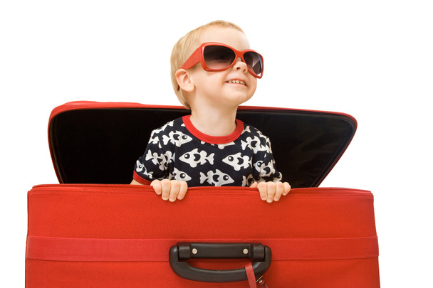 Little kid in sunglasses looking out red suitcase - Фото, зображення