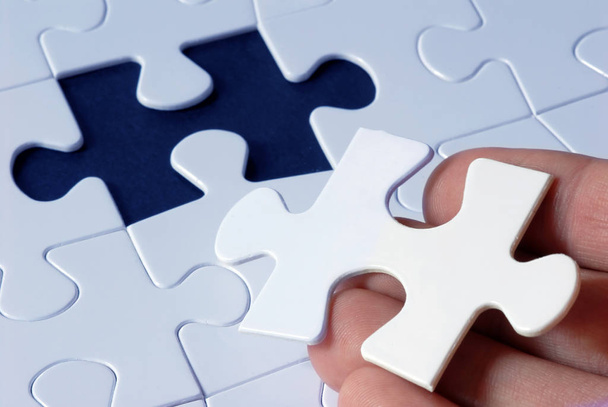hand holding puzzle piece with missing pieces - Foto, Imagen