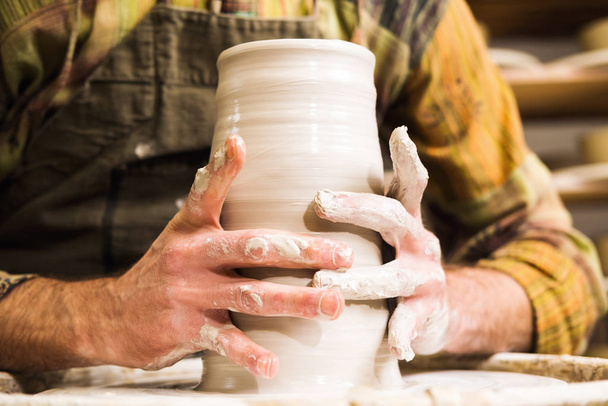 Potter en taller formando jarrón de cerámica sobre rueda. Detalle de manos
. - Foto, Imagen