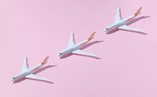 Modellek repülőgép, repülőgépek rózsaszín háttérrel. Utazási koncepció repülőgépekkel - Fotó, kép