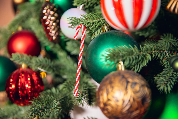 Albero di Natale ramo con decorazioni caramelle lecca-lecca canna rosso e verde palle, con luce bokeh - Foto, immagini