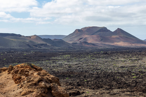 Zicht op veelkleurig vulkanisch landschap in Timanfaya Nationalpa - Foto, afbeelding