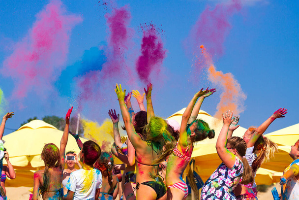 Crowds of people throw colour powder during the "Day of Colours" annual event - Foto, immagini