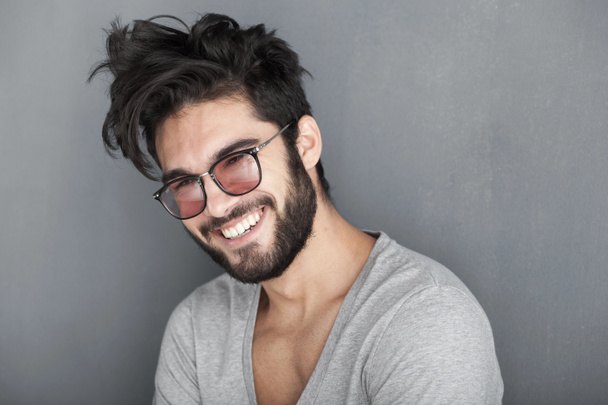 Homme sexy avec barbe souriant grand contre le mur
 - Photo, image