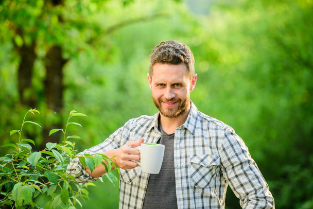 happy man with cup of tea. morning coffee. healthy lifestyle. nature and health. breakfast refreshment time. ecological life for man. man in green forest. drink tea outdoor. What a great morning - Foto, immagini