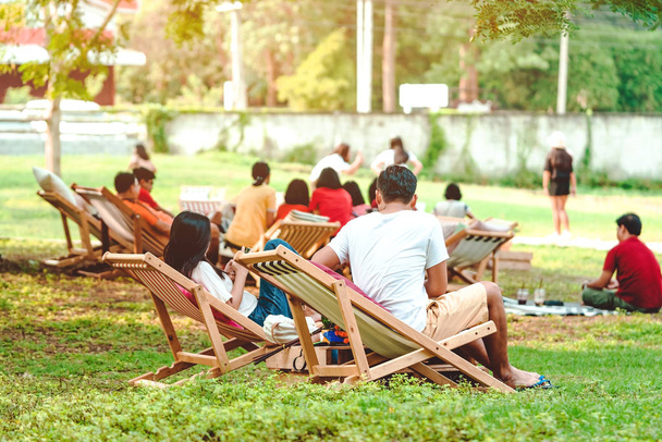 Onnellisuus pari kesälomalla istuu puutarhatuoleissa rentoutumaan julkisessa puistossa. - Valokuva, kuva