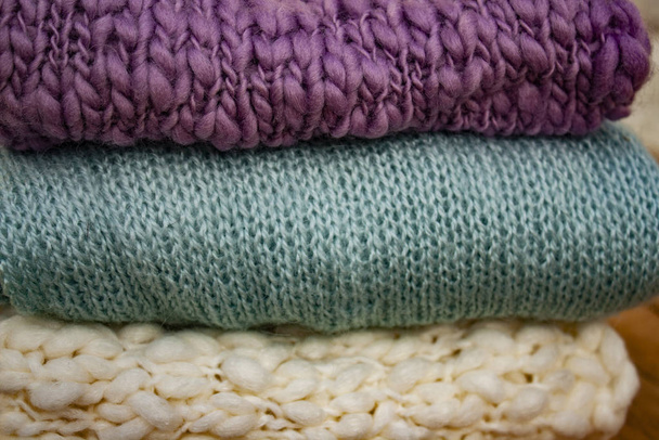 closeup of knitted things of three different colors stacked in a stack - Photo, Image