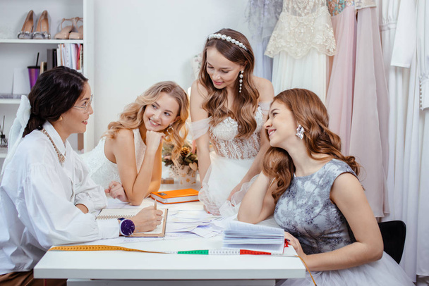 tailor designer creating a new style of wedding dress with models - Foto, afbeelding