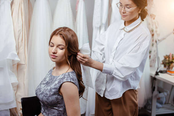 careful designer and client in wedding salon - Zdjęcie, obraz