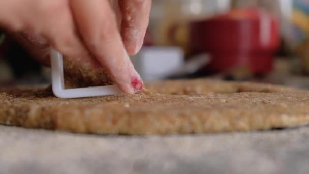 Žena ruce řezání sušenky na celé pšeničné těsto na floured pultu - Záběry, video