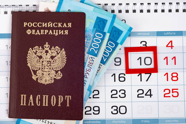 Vista dall'alto sul calendario su cui si trova un passaporto con 2.000 banconote in rublo
 - Foto, immagini