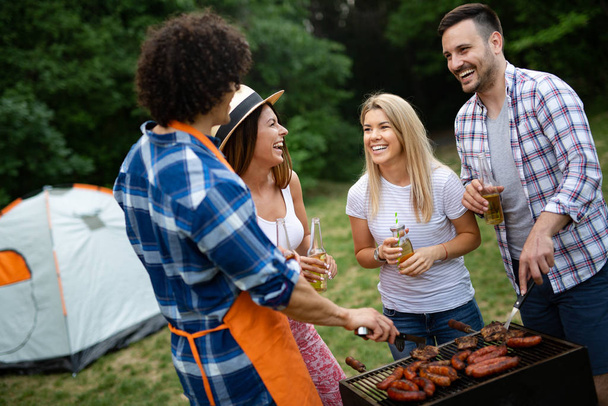 Group of friends having outdoor barbecue party and fun together - Foto, Imagen