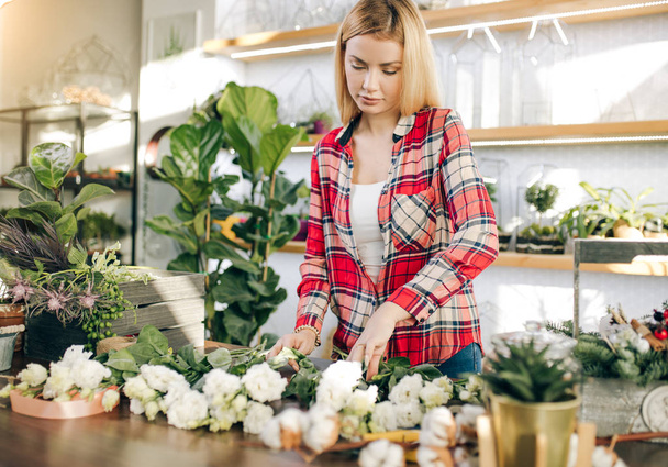 Caucasian female florist entrepreneur shopkeeper holding flowers, plants - Foto, imagen