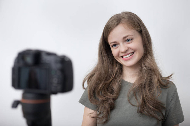 Smiling young caucasian girl woman making a video blog (vlog) with camera - Photo, Image