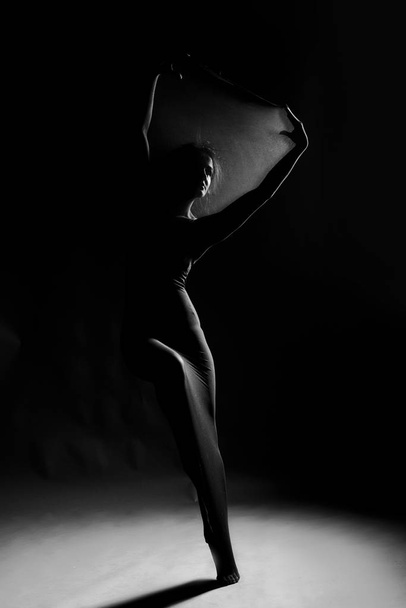Стройная девушка в белом купальнике танцует современный авангард
 - Фото, изображение