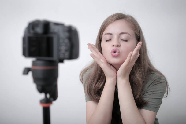 Kamerayla video blogu hazırlayan gülümseyen beyaz bir kız. - Fotoğraf, Görsel