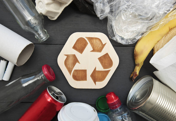 A lot of different garbage on the table and the recycling icon b - Photo, Image