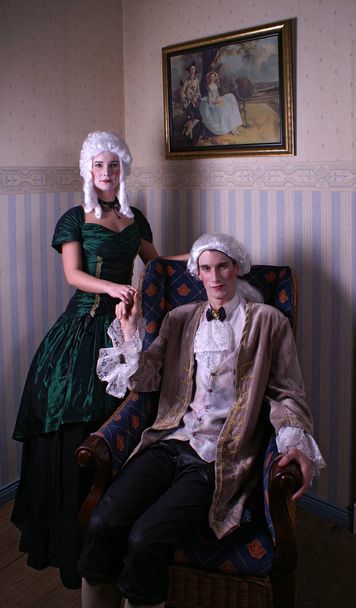 young man and woman in retro dress and a theatrical mask in her room - Photo, Image
