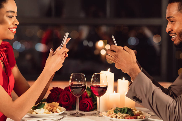 Couple utilisant des téléphones pendant le dîner romantique Date dans le restaurant de fantaisie
 - Photo, image