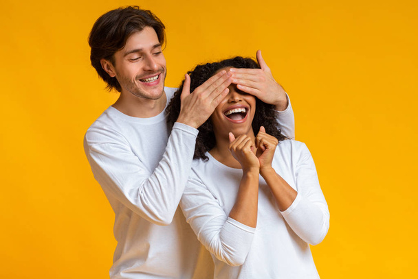Milující chlap zakrývající oči své afro přítelkyně, překvapující ji - Fotografie, Obrázek