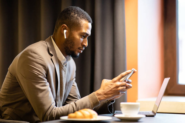 Muotokuva kiireinen musta kaveri käyttää matkapuhelin ja tietokone
 - Valokuva, kuva