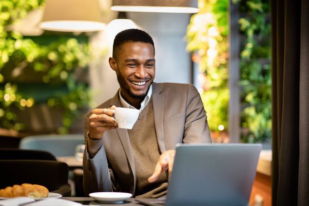 Мужчина, сидящий в кафе и пьющий кофе
 - Фото, изображение