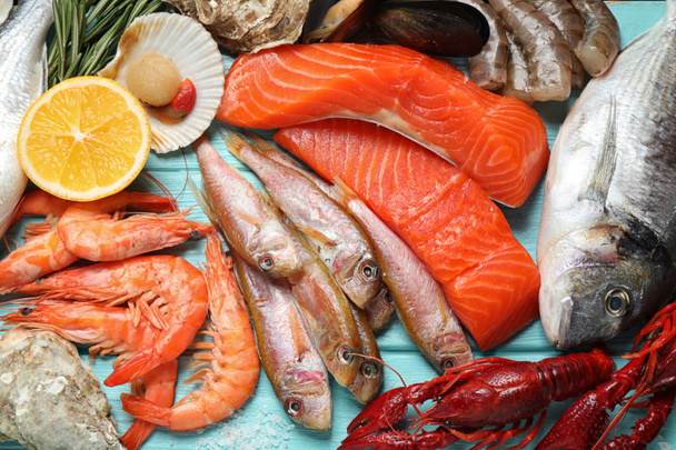 Peixe fresco e frutos do mar diferentes em mesa de madeira azul, flat lay
 - Foto, Imagem